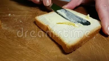 双手涂抹黄油在面包开胃菜涂抹上